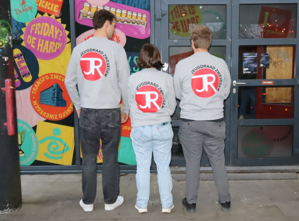 Drie leden van de kerngroep van de Jeugdraad Zwevegem die met hun rug naar de camera staan
